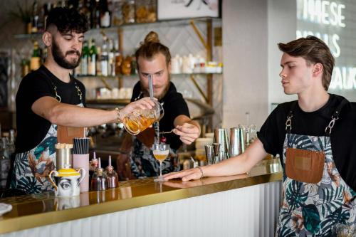 two men standing at a bar making a drink at The Box Riccione - Adults Only in Riccione