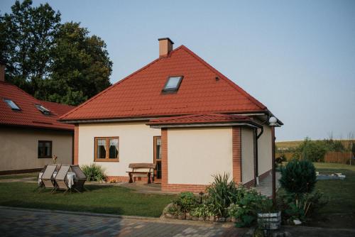 a white house with a red roof at Fotuso House in Majdany Wielkie