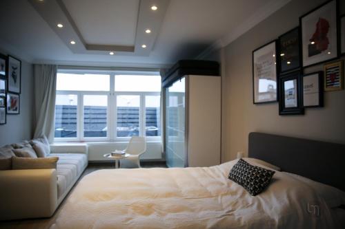 a bedroom with a bed and a couch and a window at Maison avec Jacuzzi 5ch in Verviers