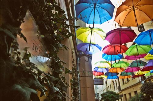 a bunch of colorful umbrellas hanging from a building at Stare Kino Cinema Residence in Łódź