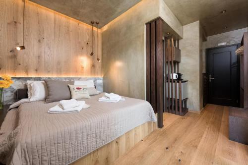 a bedroom with a bed with two towels on it at Tsikeli Boutique Hotel Meteora - Adults Friendly in Kalabaka