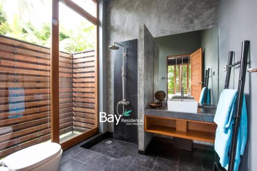 a bathroom with a shower and a sink and a toilet at Bay Villas Koh Phangan in Salad Beach