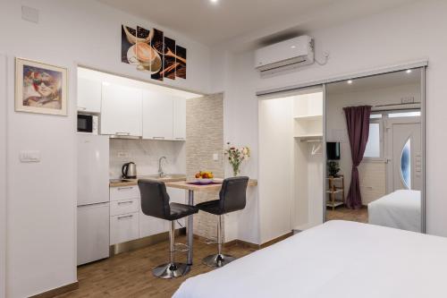 - une chambre blanche avec un lit, une table et des chaises dans l'établissement Apartments Martha, à Dubrovnik