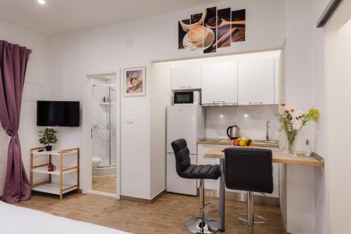 a kitchen with white cabinets and a table and chairs at Apartments Martha in Dubrovnik