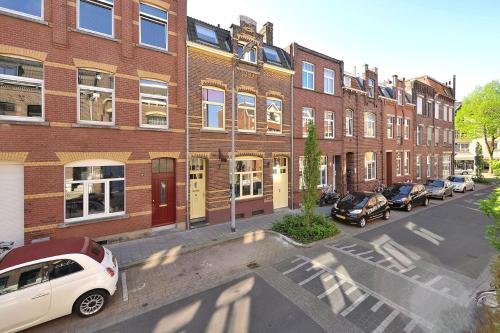 a city street with cars parked in front of brick buildings at Inn den Acht Venlo in Venlo
