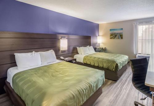 a hotel room with two beds and a chair at Quality Inn near MCAS Cherry Point in Havelock