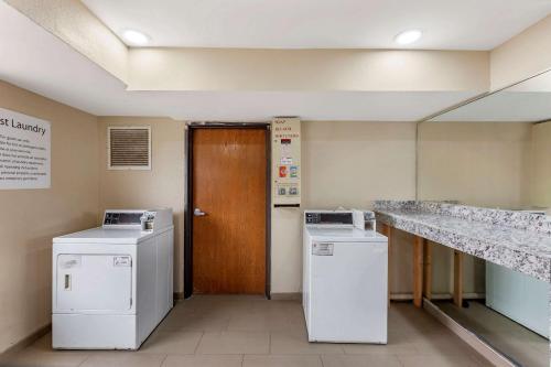 a laundry room with two washers and a wooden door at Clarion Pointe Racine - Mount Pleasant in Racine