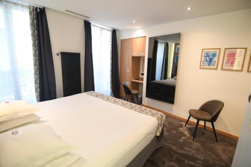 a hotel room with a bed and a mirror at Hotel Aida Opera in Paris