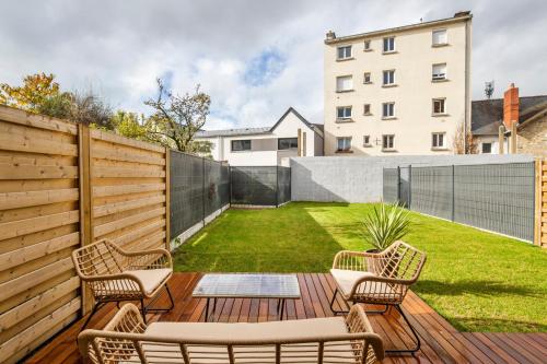 a backyard with a wooden deck with chairs and a lawn at Maison Elleviou - Grande Maison à deux pas du centre in Rennes