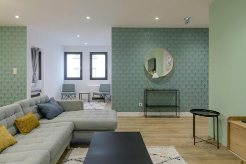 salon z kanapą i lustrem w obiekcie NOCNOC - Le Donatello w mieście Lyon