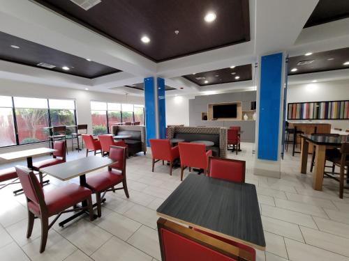 a dining room with tables and red chairs at Holiday Inn Express Hotel & Suites Vidor South by IHG in Vidor