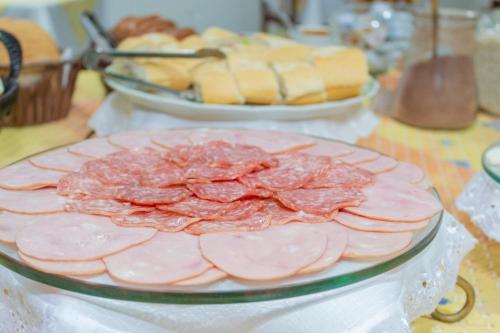 une table recouverte de plaques de viande et de pain dans l'établissement Hotel Vitoria - Itajaí, à Itajaí