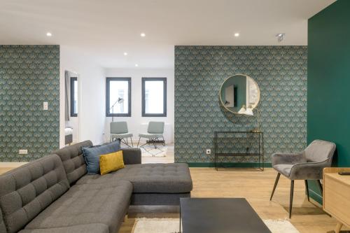 ein Wohnzimmer mit einem grauen Sofa und einer grünen Wand in der Unterkunft NOCNOC - Le Michelangelo in Lyon