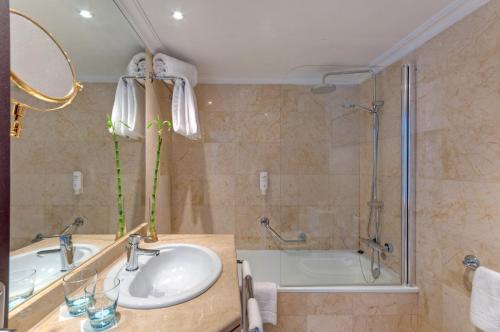 y baño con lavabo, ducha y bañera. en Hotel Alicante Gran Sol, affiliated by Meliá, en Alicante