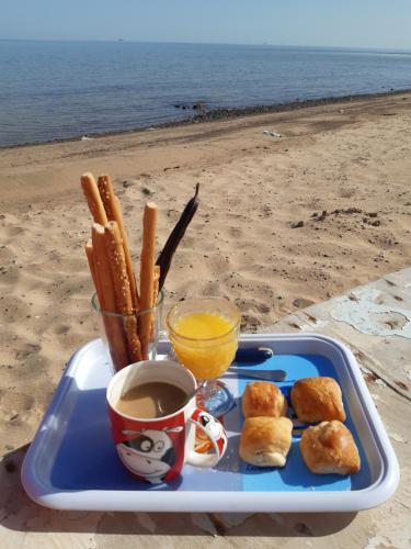 a tray of food with a drink and biscuits and orange juice at вилла Coral Paradise in Safaga 