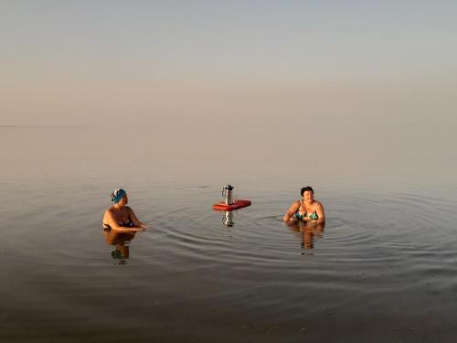 two people are sitting in the water at вилла Coral Paradise in Safaga 