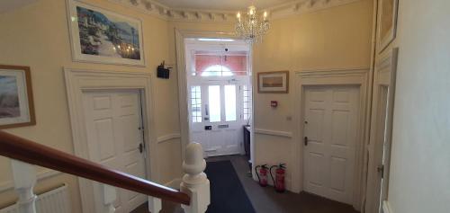 a hallway with two white doors and a chandelier at sunnylodge in Folkestone