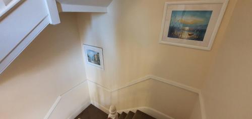 a white staircase with two pictures on the wall at sunnylodge in Folkestone