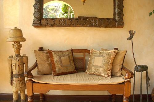 a bench with pillows on it in a room at Palacina The Residence & The Suites in Nairobi