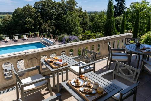 a patio with tables and chairs next to a pool at Le Château des Forges in Angers