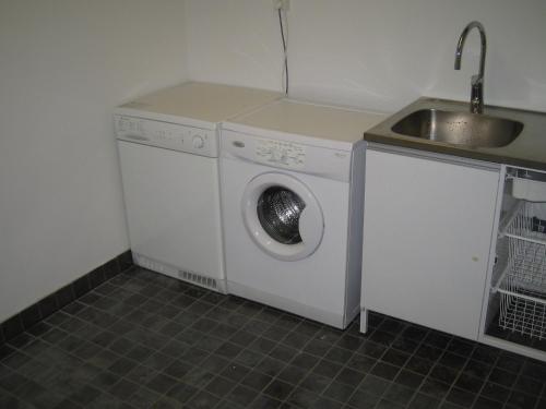 eine Waschmaschine in einer Küche mit Spüle in der Unterkunft Loft Ålaryd in Skillingaryd