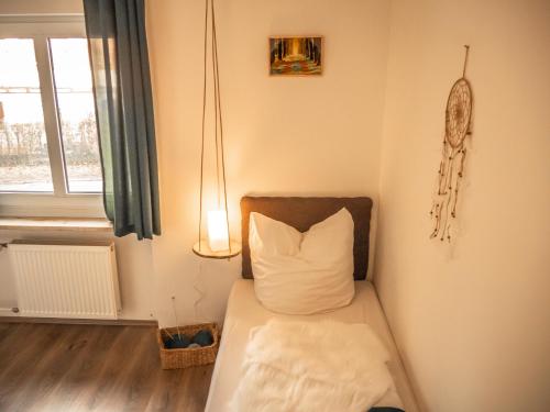 a room with a bed with a pillow and a window at Waldpension Zollhaus in Nürnberg