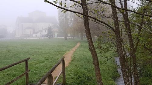 a field with a fence and a dirt path at SAKURA in Fontaine-le-Comte