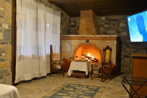 een woonkamer met een tafel en een open haard bij Pir Efes Konakları in Izmir