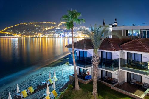 a hotel with a view of the water at night at Panorama Hotel - All Inclusive in Alanya