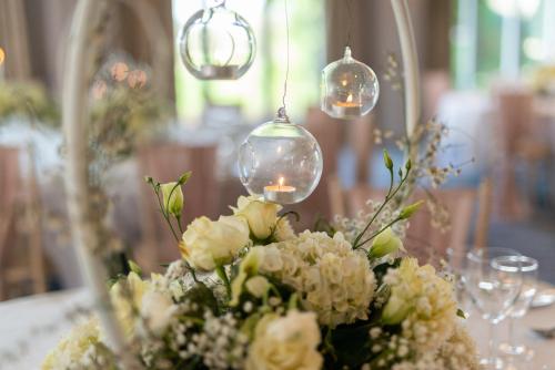 a vase of flowers on a table with lights at Mercure Blackburn Dunkenhalgh Hotel & Spa in Blackburn
