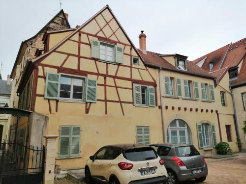 deux voitures garées devant une maison dans l'établissement La Cour de Berthe Ouest, à Colmar