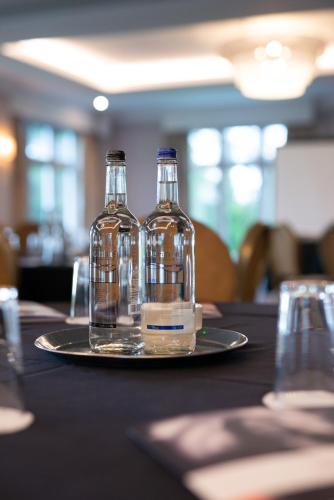 two bottles of water on a plate on a table at Mercure Blackburn Dunkenhalgh Hotel & Spa in Blackburn