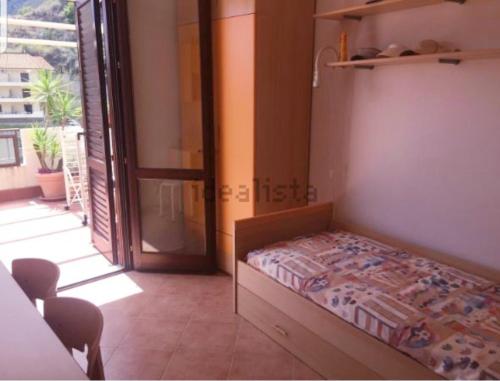 um quarto com uma cama e uma porta para uma varanda em Estella Mare em Letojanni