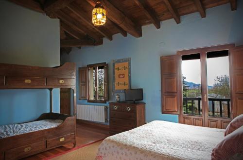 a bedroom with two beds and a television in it at El Cajigal de Quintana in Espinosa de los Monteros