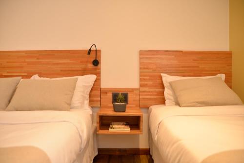 two beds sitting next to each other in a bedroom at TAS D VIAJE Suites - Hostel Boutique in Punta del Este