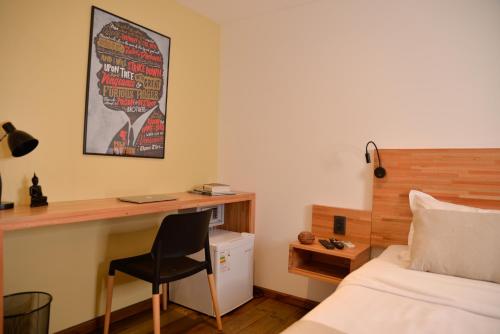 a bedroom with a bed and a desk and a chair at TAS D VIAJE Suites - Hostel Boutique in Punta del Este