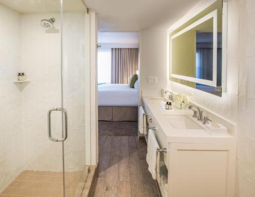 a bathroom with a sink and a shower at Beach House Suites by the Don CeSar in St. Pete Beach