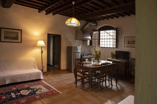 a kitchen and living room with a table and a bed at Quercesecca in Marina di Grosseto