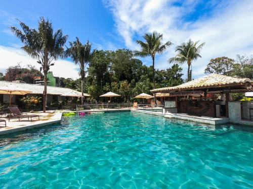 a swimming pool at a resort with palm trees at Hotel Solar do Imperador in Porto Seguro