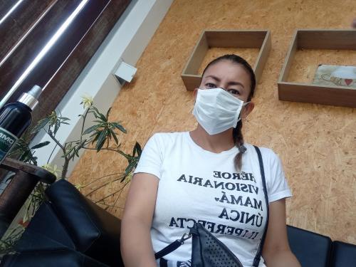 a woman wearing a face mask while sitting at Hotel Los Estoraques in Aguachica