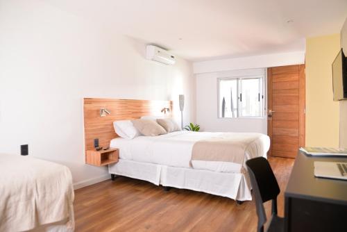 a bedroom with two beds and a desk at TAS D VIAJE Suites - Hostel Boutique in Punta del Este