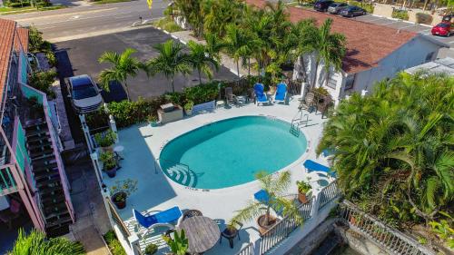 einen Blick über einen Pool mit Palmen und Stühlen in der Unterkunft Sand Vista Motel in St Pete Beach