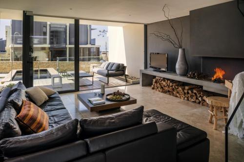 a living room with a couch and a fireplace at Areias do Seixo Villas in Santa Cruz