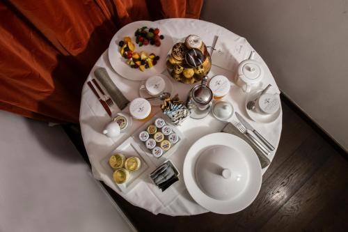 
a white table topped with plates of food at Magna Pars l'Hotel à Parfum in Milan
