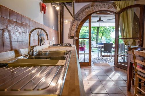 een keuken met een spoelbak en een open deur naar een terras bij Giacomazzi House BRI in Malcesine