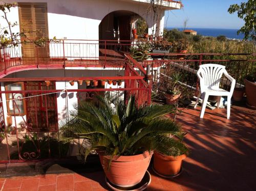 a balcony with a white chair and potted plants at Rosa di Calabria in Bovalino Marina