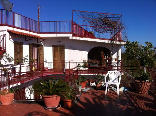 a house with a red balcony and a white chair at Rosa di Calabria in Bovalino Marina