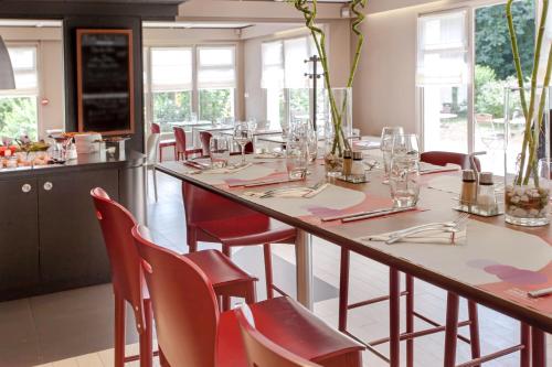 a dining room with a long table and chairs at Campanile Angers Ouest - Beaucouzé in Beaucouzé