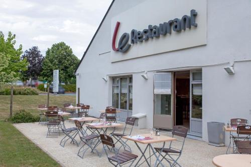 a restaurant with tables and chairs outside of it at Campanile Angers Ouest - Beaucouzé in Beaucouzé