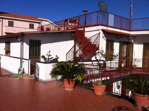 a apartment building with a staircase and potted plants at Rosa di Calabria in Bovalino Marina